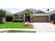 Charming one-story home featuring tidy landscaping, beautiful lawn, and neutral tones at 9824 Secret Cove Ln, Orlando, FL 32832
