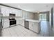 Bright kitchen featuring white cabinets, stainless appliances, an island, and tile flooring at 9824 Secret Cove Ln, Orlando, FL 32832