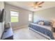 Bright bedroom with neutral walls, light floors, and windows looking out onto a green lawn at 1021 Golden Dawn Loop, Minneola, FL 34715