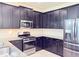 Well-appointed kitchen featuring stainless steel appliances, granite countertops, ample dark wood cabinetry, and stylish tile flooring at 1021 Golden Dawn Loop, Minneola, FL 34715