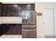 Kitchen featuring stainless steel refrigerator, granite countertops, dark wood cabinets, and a convenient door to the outside at 1021 Golden Dawn Loop, Minneola, FL 34715