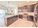 A spacious kitchen features granite counters, modern appliances, dark wood cabinets, and an open layout to the living area at 1021 Golden Dawn Loop, Minneola, FL 34715