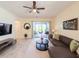 Spacious living room with tile floors, comfortable seating, and a sliding glass door to the patio for indoor-outdoor living at 1021 Golden Dawn Loop, Minneola, FL 34715