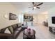 Open-concept living room flows into kitchen, featuring dark cabinetry, granite counters, and modern stainless steel appliances at 1021 Golden Dawn Loop, Minneola, FL 34715