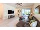 Bright living area with sliding glass doors to the outdoor patio, neutral color palette, and comfortable seating at 1021 Golden Dawn Loop, Minneola, FL 34715