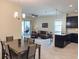 Open floor plan featuring kitchen, dining, and living areas, complete with tile flooring, modern furniture, and sliding glass doors at 1021 Golden Dawn Loop, Minneola, FL 34715