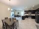 Open-concept layout connects dining, living, and kitchen, featuring stylish tile flooring, dark wood cabinets, and modern furnishings at 1021 Golden Dawn Loop, Minneola, FL 34715