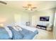 Bright main bedroom featuring ceiling fan, flatscreen TV, and en-suite bath at 1021 Golden Dawn Loop, Minneola, FL 34715