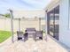 Enclosed patio has an outdoor seating area with a retractable shade, offering a private space for relaxation at 1021 Golden Dawn Loop, Minneola, FL 34715