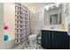 Clean bathroom featuring a patterned shower curtain, a vanity with dark blue cabinets, and a tile floor at 114 Harwood Cir, Kissimmee, FL 34744