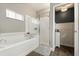Bright bathroom featuring a soaking tub, separate shower with glass doors, and neutral color scheme at 114 Harwood Cir, Kissimmee, FL 34744