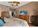 Cozy bedroom featuring a large dresser, TV, warm tones, and a comfortable bed with stylish bedding at 114 Harwood Cir, Kissimmee, FL 34744