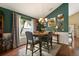 Dining area with a wooden table, gray chairs, stylish decor, and a view through the window at 114 Harwood Cir, Kissimmee, FL 34744