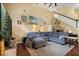 Spacious living room with a large gray sectional sofa, decorative art, and a staircase to the second floor at 114 Harwood Cir, Kissimmee, FL 34744