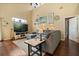 Cozy living room with a sectional sofa, wood floors, and walls decorated with pictures and decor at 114 Harwood Cir, Kissimmee, FL 34744