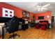 Living area with a home office setup, a gaming chair, and an orange accent wall at 114 Harwood Cir, Kissimmee, FL 34744