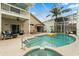 Inviting pool area featuring a spa, covered seating, and a second-story balcony with comfortable seating at 114 Harwood Cir, Kissimmee, FL 34744