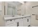 Bathroom featuring double sinks, white cabinets with black handles, and a large mirror at 11844 Founders St, Orlando, FL 32832