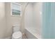 Clean bathroom featuring a white toilet, bathtub, and a window for natural light at 11844 Founders St, Orlando, FL 32832