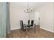 Dining room with glass table, modern chairs, decorative chandelier, and wood-look flooring at 11844 Founders St, Orlando, FL 32832