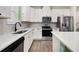 Kitchen featuring stainless appliances, white cabinets, white counters, and wood-look floors at 11844 Founders St, Orlando, FL 32832