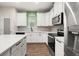 Beautiful kitchen featuring stainless appliances, white cabinets, counters, and wood-look floors at 11844 Founders St, Orlando, FL 32832