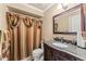Bathroom with granite vanity, decorative shower curtain, mirror, and updated fixtures, showcasing a functional space at 12542 Idaho Woods Ln, Orlando, FL 32824
