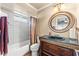 Traditional bathroom with a round mirror, and vanity with granite counters and lots of storage at 12542 Idaho Woods Ln, Orlando, FL 32824