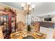 Formal dining room featuring a glass table set for a meal, decorative china cabinet, and elegant chandelier at 12542 Idaho Woods Ln, Orlando, FL 32824