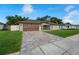 Inviting single-story home with a brick driveway, lush grass and well-maintained landscaping at 12542 Idaho Woods Ln, Orlando, FL 32824