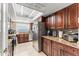 Open kitchen showcasing stainless steel appliances, granite counters, and wood cabinets offering ample storage space at 12542 Idaho Woods Ln, Orlando, FL 32824