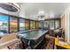 Enclosed sunroom with large windows, ceiling fans, and billiard table for leisure at 12542 Idaho Woods Ln, Orlando, FL 32824
