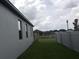 View of the side yard with healthy grass and a white fence at 1292 Hilltop Pl, St Cloud, FL 34772