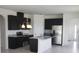 Modern kitchen with stainless steel appliances, dark cabinets, granite countertops, and a center island at 1292 Hilltop Pl, St Cloud, FL 34772