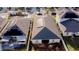 Aerial view featuring homes with solar panels, landscaped yards, driveways, and community street at 153 Taft Dr, Davenport, FL 33837