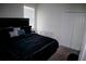 Bedroom showcasing a black bed, white walls, and a double door closet with blinds on the window at 153 Taft Dr, Davenport, FL 33837