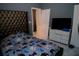 Nicely staged bedroom with tufted headboard, modern dresser, and marble tile floors at 153 Taft Dr, Davenport, FL 33837