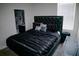Cozy bedroom with a tufted headboard, dark bedding, and attached bathroom, complete with a suitcase at 153 Taft Dr, Davenport, FL 33837