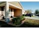 Beige single-story home featuring a front porch, stone accents, well manicured lawn and landscaping at 153 Taft Dr, Davenport, FL 33837