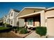 Beige single-story home featuring a front porch, stone accents, well manicured lawn and landscaping at 153 Taft Dr, Davenport, FL 33837