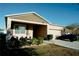 Beige single-story home featuring a front porch, stone accents, well manicured lawn and landscaping at 153 Taft Dr, Davenport, FL 33837