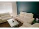 Living room with white sofas, glass coffee table, and dark blue accent wall at 153 Taft Dr, Davenport, FL 33837