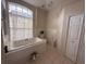 Bright bathroom features a large soaking tub, window, and tiled floor at 216 Boxwood Dr, Davenport, FL 33837