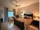 Comfortable bedroom features a ceiling fan, neutral colors, and cozy seating area by the window at 216 Boxwood Dr, Davenport, FL 33837