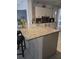 Modern kitchen with granite countertops, white cabinetry, and a functional island with seating at 216 Boxwood Dr, Davenport, FL 33837