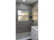 Bathroom featuring tiled walls and pebble tile shower with a frosted window at 217 W Chelsea St, Deland, FL 32720