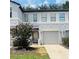 Charming townhome with a well-manicured lawn, blooming tree, and one-car garage at 2242 Seven Oaks Dr, St Cloud, FL 34772