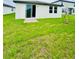 Exterior shot of backyard featuring a lawn and the back of the house with patio door at 2505 Merseyside Ct, Haines City, FL 33844