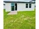View of the back of the home with a small patio and a spacious grassy backyard at 2505 Merseyside Ct, Haines City, FL 33844