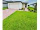 Charming single-story home with a well-manicured lawn and a brick paver walkway leading to the front door at 2505 Merseyside Ct, Haines City, FL 33844